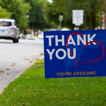 a yard sign by street saying "Thank you, you are awesome" in white and orange text on blue background. A red heart symbol is embedded. Customizable versatile image with copy space for additional text